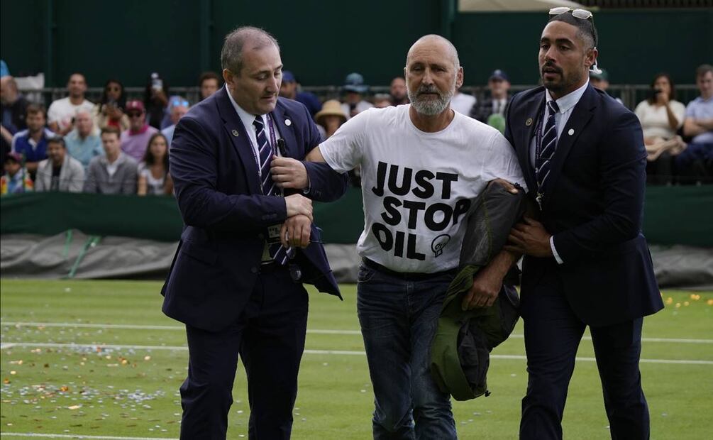 Un manifestante de Just Stop Oil es retirado de la Corte 18 el miércoles en el tercer día de los campeonatos de tenis de Wimbledon en Londres. Foto: AP