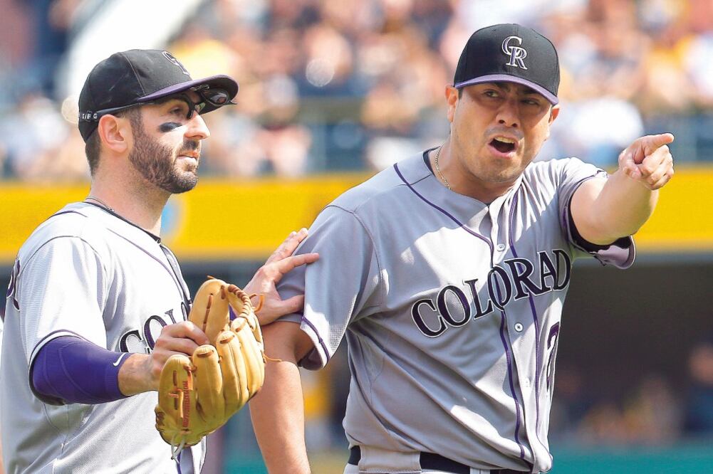 El pitcher Jorge de la Rosa (der.) discutió con el umpire Jeff Nelson, mientras que Daniel Descalso trató de calmarlo (KEITH SRAKOCIC. AP)