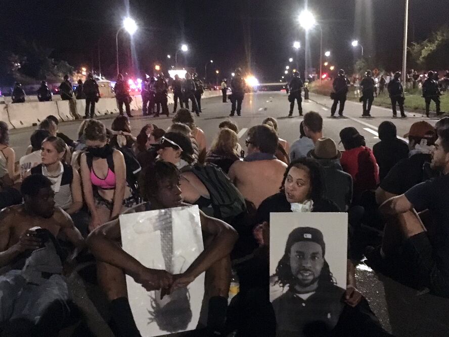 Agentes de policía forman una línea que cruza la interestatal 94 la noche del sábado 9 de julio, en St. Paul, Minnesota, en respuesta a los manifestantes que bloquearon la autovía durante una protesta contra la brutalidad policial (AP Foto/Joe Danborn)