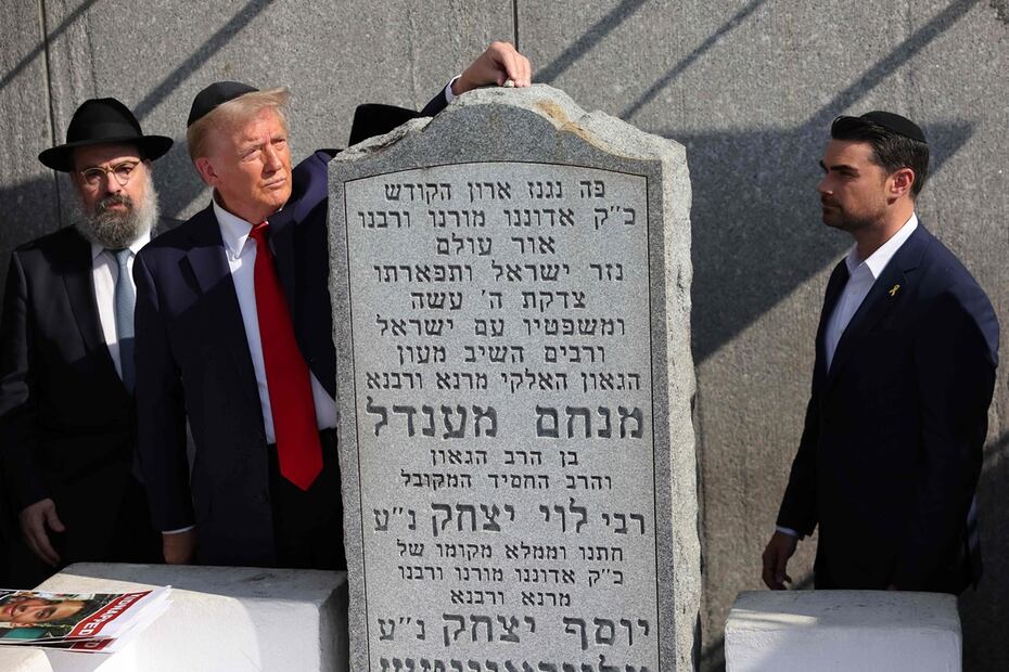 El candidato presidencial republicano, el exmandatario estadounidense Donald Trump, coloca una piedra sobre una lápida mientras Ben Shapiro observa en Ohel Chabad Lubavitch el 7 de octubre de 2024 en la ciudad de Nueva York. Foto: AFP