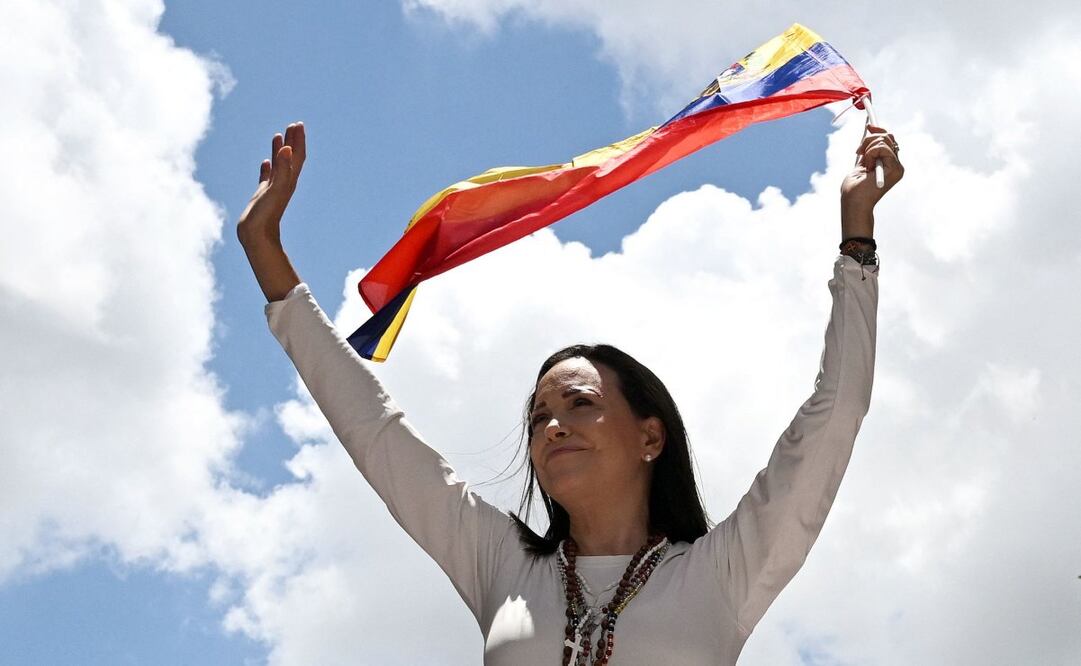 La líder opositora venezolana María Corina Machado ondea una bandera venezolana durante un mitin en Caracas el 28 de agosto de 2024. La Fiscalía General de Venezuela abrió el 22 de noviembre una nueva investigación contra la líder opositora María Corina Machado, acusada de traición por conspirar con El gobierno de Joe Biden impulsará en Estados Unidos un proyecto de ley para aislar aún más económicamente al Ejecutivo de Nicolás Maduro. Foto: AFP