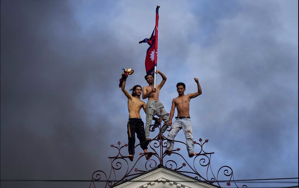 Manifestantes celebran en la cima del palacio Singha Durbar, sede del Parlamento y oficinas del gobierno de Nepal, después de que fuera incendiado durante una protesta contra la prohibición de las redes sociales y la corrupción en Katmandú, Nepal, el 9 de septiembre de 2025. Foto: AP