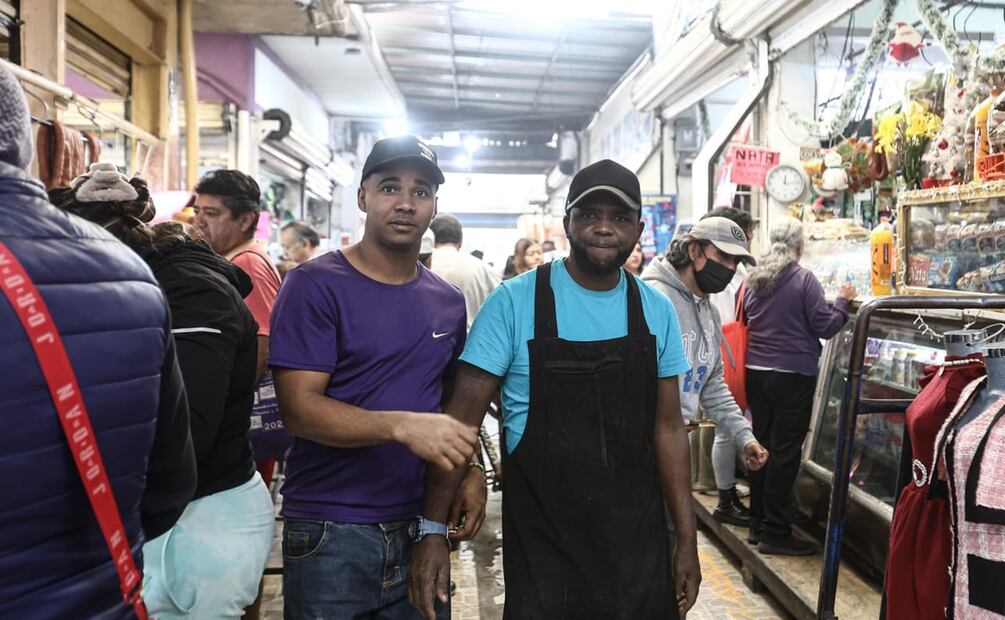 Dairon, de Cuba, y Francis,de República Dominicana, son dos migrantes que trabajan en el Mercado Nezahualcoyotl. Foto: Gabriel Pano El Universal