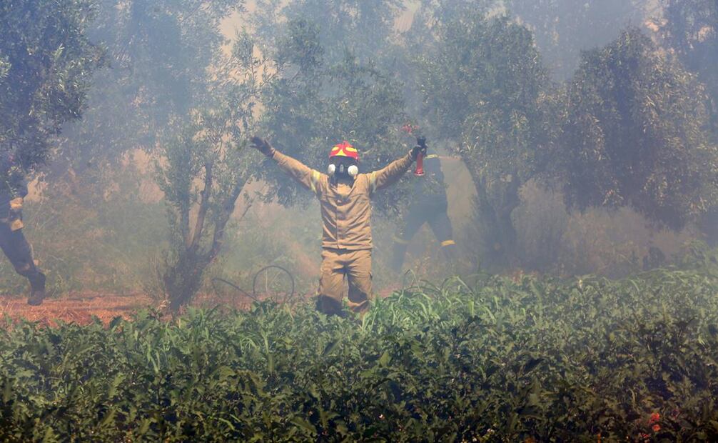 Bomberos trabajan para extinguir el incendio en Marathon, al norte de Atica. Foto: EFE