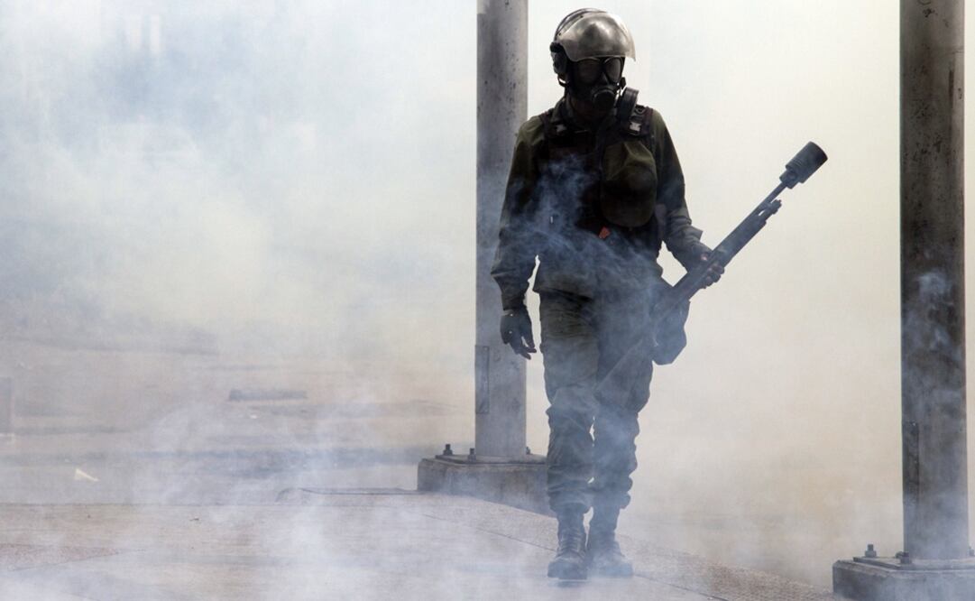 Un elemento de las fuerzas de seguridad reacciona durante un enfrentamiento en una protesta en Caracas (Foto: Xinhua)