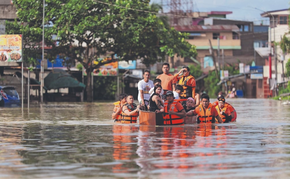 Rescatistas arrastran una lancha inflable con residentes a bordo durante una evacuación forzosa en una aldea de Tuguegarao, Cagayán, Manila. Foto: de JOHN DIMAIN. AFP