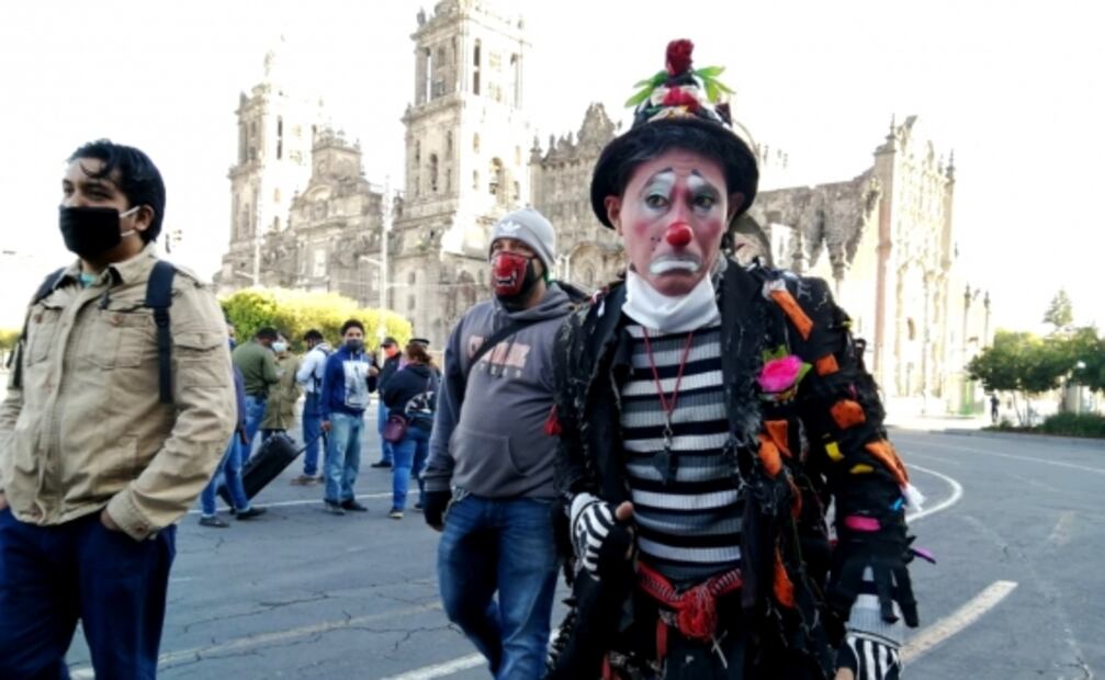 Payasos y cirqueros hacen malabares frente a Palacio Nacional