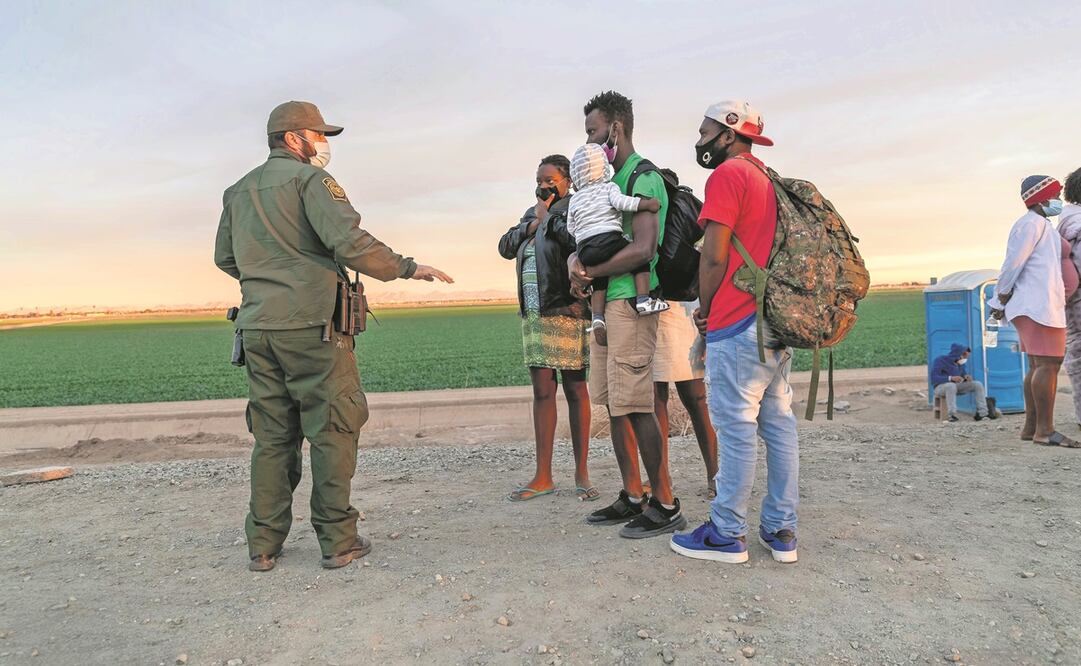 Un agente fronterizo revisa los pasaportes de haitianos, después de que cruzaron la frontera en Yuma, Arizona. Foto: John Moore. AFP