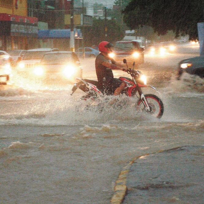 Un motociclista transita por una avenida inundada por las lluvias torrenciales provocadas por Lorena en la ciudad de Culiacán. Foto/JUAN CARLOS CRUZ. EFE