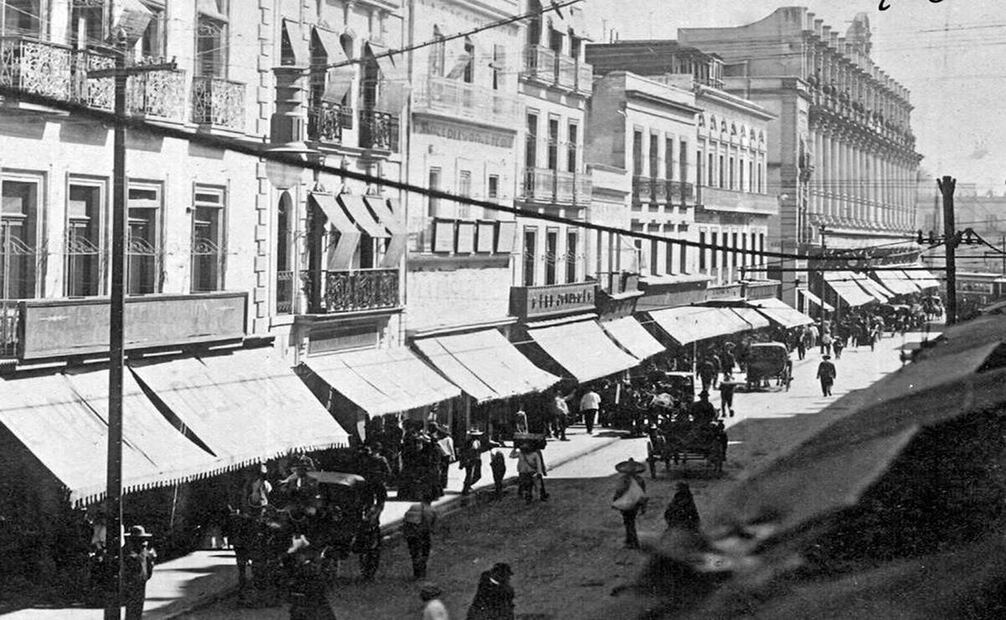 Fotografía cercana a 1908 de las calles 1a y 2a del Refugio, hoy 16 de Septiembre, entre Isabel la Católica y el Zócalo. Al fondo el Centro Mercantil, construido a finales del siglo XIX, que hoy alberga el Gran Hotel de la Ciudad de México, zona de sesiones espiritistas de Madero y seguidores. Imagen: Col. Particular. Referencia La Luz en México. Periódico Espírita, 1872-1873. “Imprenta La Bohemia Literaria, Portal del Coliseo Viejo, núm. 8”, actual avenida 16 de Septiembre.