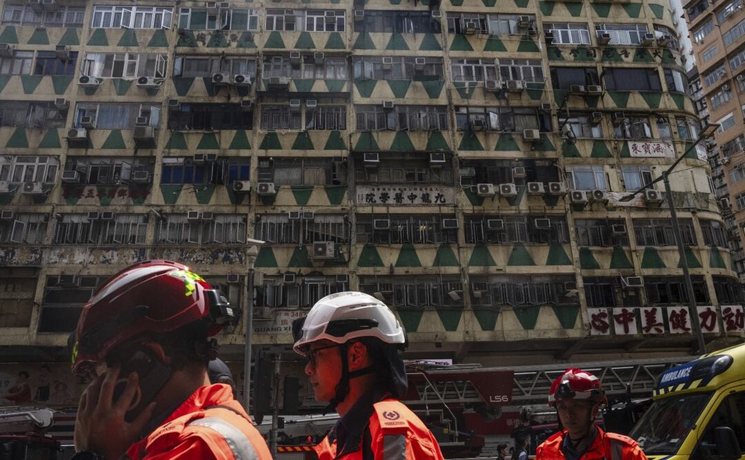 Bomberos caminan frente a un edificio de nombre New Lucky House en donde se originó un incendio, el miércoles 10 de abril de 2024, en Hong Kong.. Foto: AP