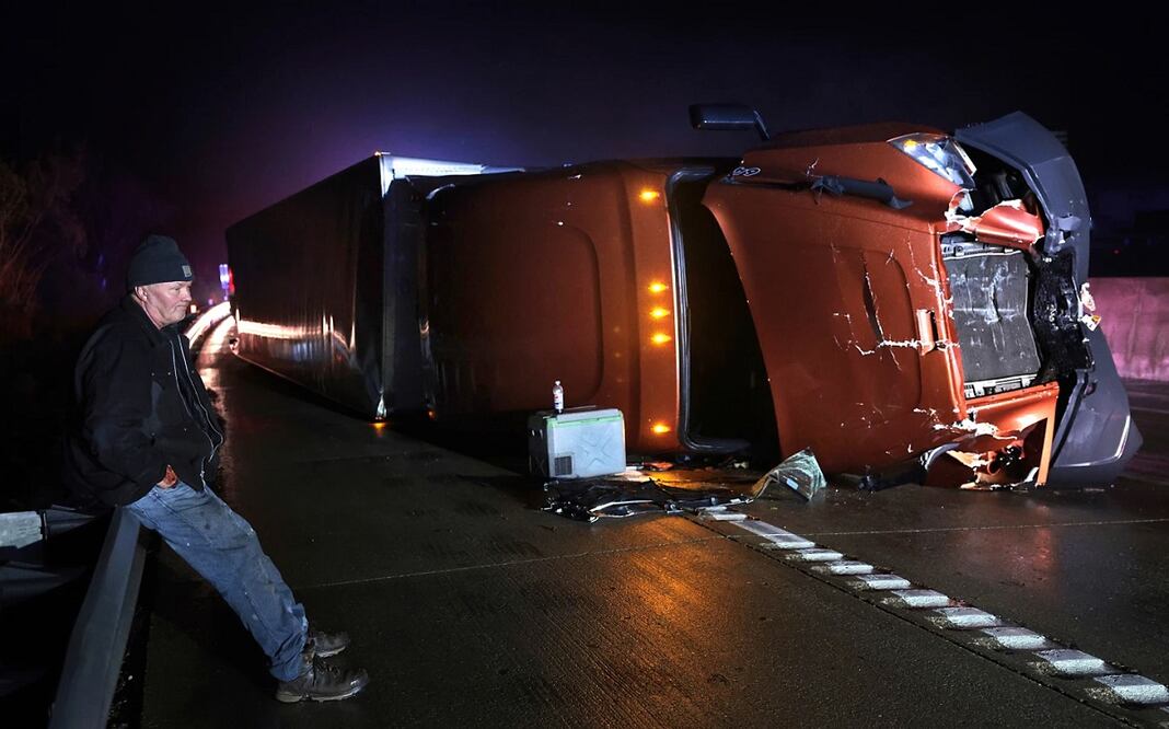Mark Nelson, de Wisconsin, espera junto a su tráiler, que volcó durante un episodio de potentes vientos y un posible tornado en la carretera interestatal 44 en dirección oeste en Villa Ridge, Missouri, el 14 de marzo de 2025. Foto: AP