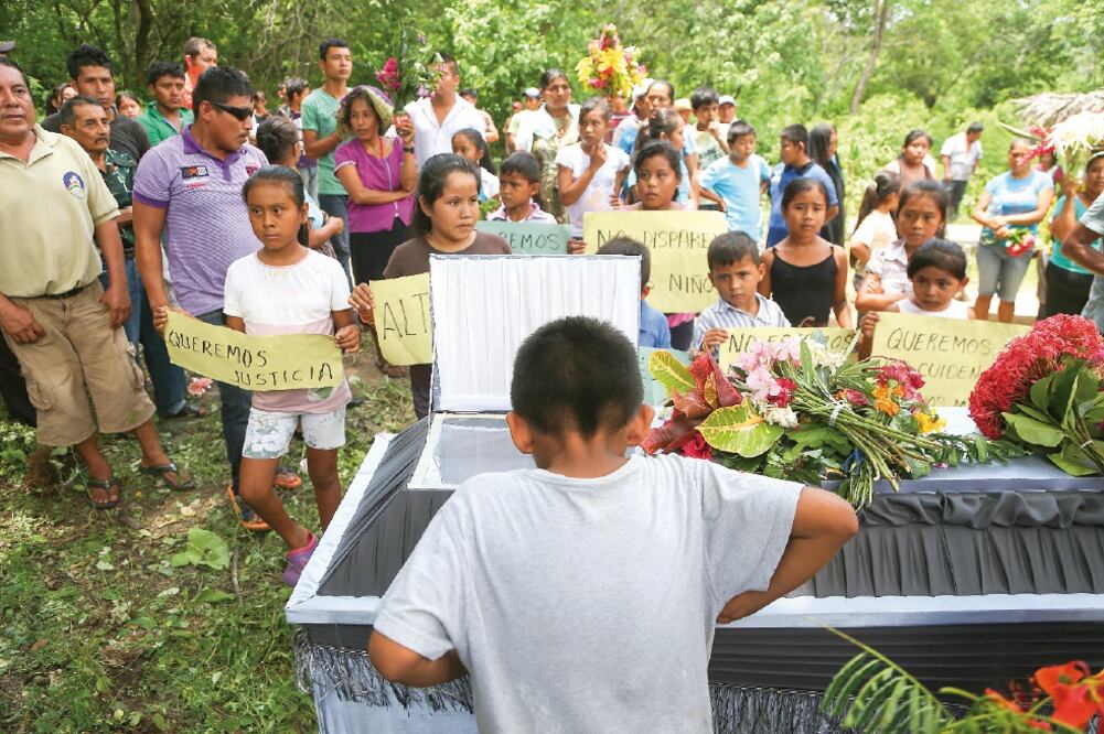 Amigos y compañeros portaron pancartas durante el velorio del pequeño Edilberto, niño de 12 años que murió el domingo al ser alcanzado por una bala pérdida durante un enfrentamiento con militares para evitar la detención de Semeí Verdía, líder comunitario