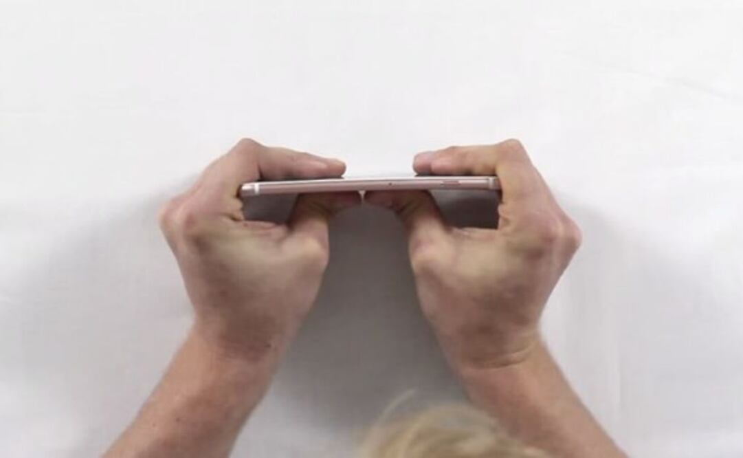 Se incorpora una persona más para ayudar al primero a doblar el iPhone 6S y el resultado es el mismo; tras un par de intentos entre ambos, por fin el celular comienza a doblarse