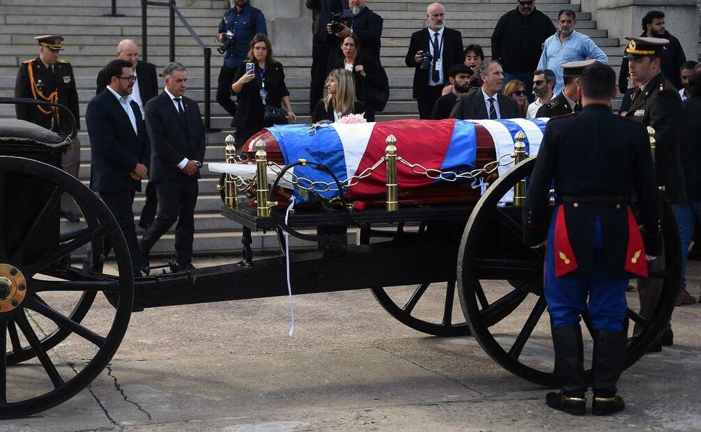 El presidente de Uruguay, Yamandu Orsi (4.º por la izq.), el secretario de la Presidencia, Alejandro Sánchez (2.º por la izq.) y su esposa, Laura Alonso Pérez (centro), rinden homenaje al cortejo fúnebre del expresidente uruguayo José "Pepe" Mujica en el Palacio Legislativo de Montevideo, el 14 de mayo de 2025, un día después de su fallecimiento. Mujica, exguerrillero y héroe de la izquierda latinoamericana, falleció el 13 de mayo de 2025 a los 89 años. El humilde líder, que pasó doce años en prisión por su actividad revolucionaria, perdió la batalla contra el cáncer tras anunciar en enero que la enfermedad se había propagado y que suspendería el tratamiento. Foto: AFP