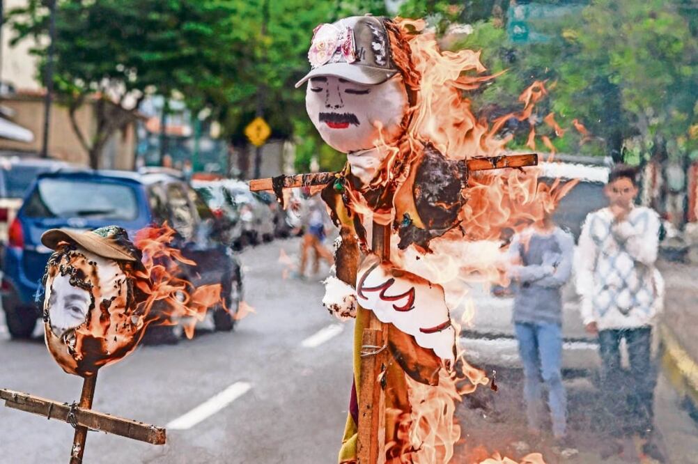 Ciudadanos destruyen una figura del presidente Nicolás Maduro durante la tradicional “quema de Judas”, ayer en la ciudad de Caracas. (JUAN BARRETO. AFP)