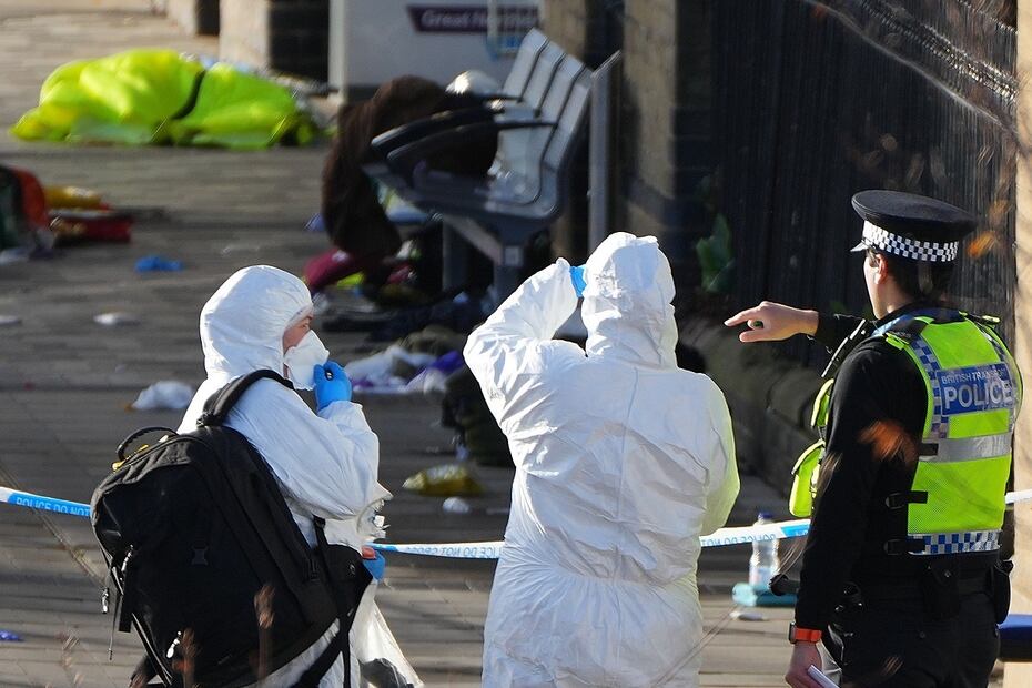 Investigadores forenses revisan el área donde viajero dejaron sus pertenencias tras un apuñalamiento masivo en un tren, en Huntingdon, Inglaterra. FOTO: KIRSTY WIGGLESWORTH. AP
