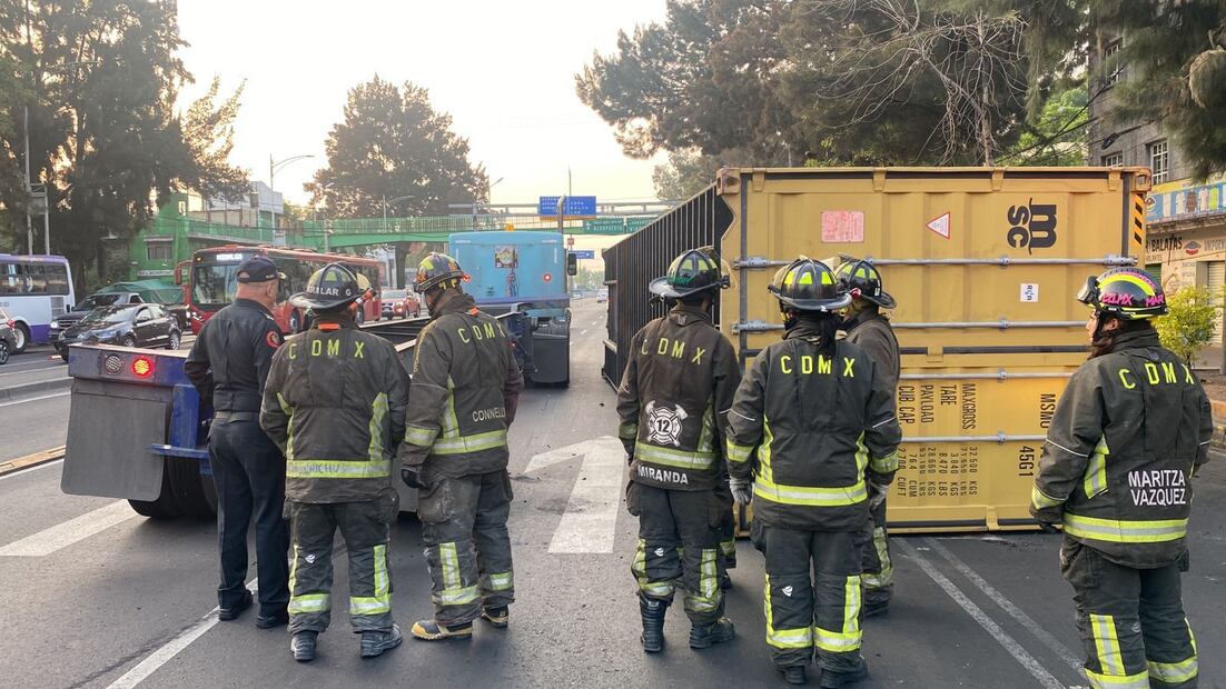Bomberos laboran para colocar en su posición normal un contenedor de un trailer que se le zafó y volcó en la esquina de Eje 1 Norte y Oriente 172 en la colonia Moctezuma en Venustiano Carranza. Foto: Isidro Corro / EL UNIVERSAL