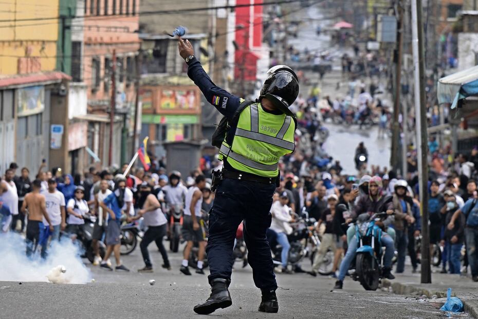 Un policía antidisturbios utiliza gases lacrimógenos contra manifestantes durante una protesta de opositores al gobierno del presidente venezolano Nicolás Maduro, en Caracas. Foto Yuri Cortez AFP
