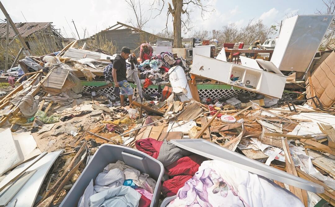 Una familia, con lo que quedó de su hogar tras el paso de Ida en Golden Meadow, Louisiana. La tormenta golpeó el domingo con vientos máximos de 240 kilómetros por hora. Foto: DAVID J. PHILLIP. AP