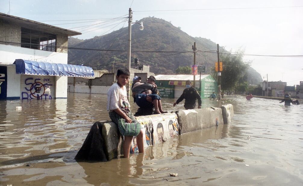 Un menor espera resignado, con aguas negras del Canal de la Compañía a sus pies, tras la inundación en Chalco, 2000. Foto: Agustín Martínez/Arc EL UNIVERSAL.