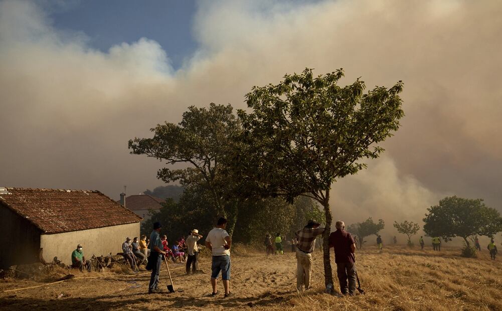 Residentes y bomberos combaten un incendio que avanza hacia el pueblo de Rebordondo, cerca de Ourense, en el noroeste de España, el lunes 18 de agosto de 2025. Foto: AP