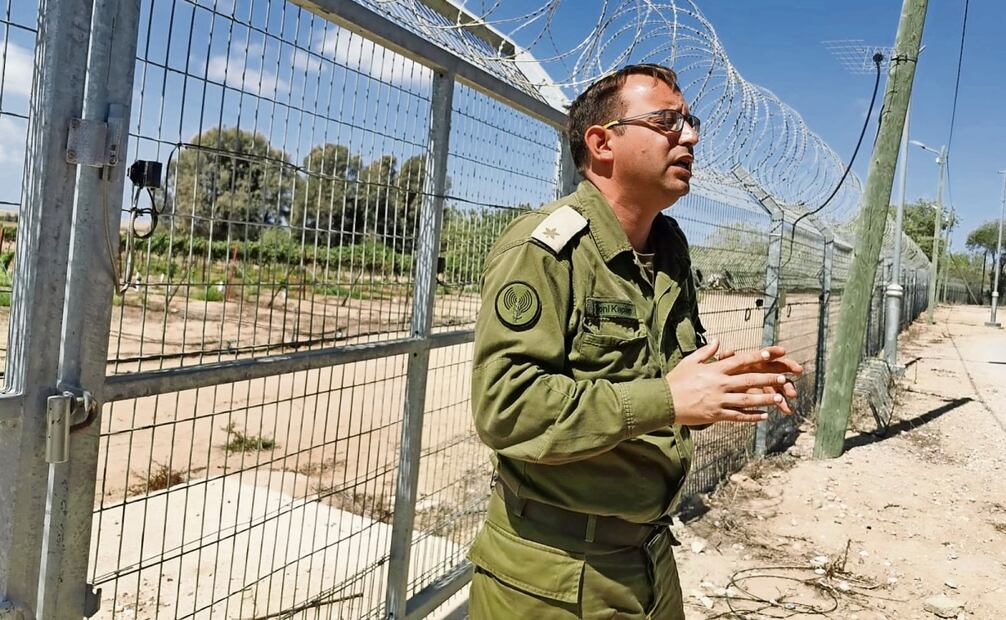 El mayor Roni Kaplán, portavoz del ejército israelí, enfrente de una gran valla metálica, de más de dos metros de altura, que arriba tiene púas. Foto: Ángel Santamaría