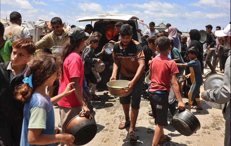 Palestinos, muchos de ellos niños, acuden a la repartición de comida cerca del puerto de la ciudad de Gaza. Foto: AFP