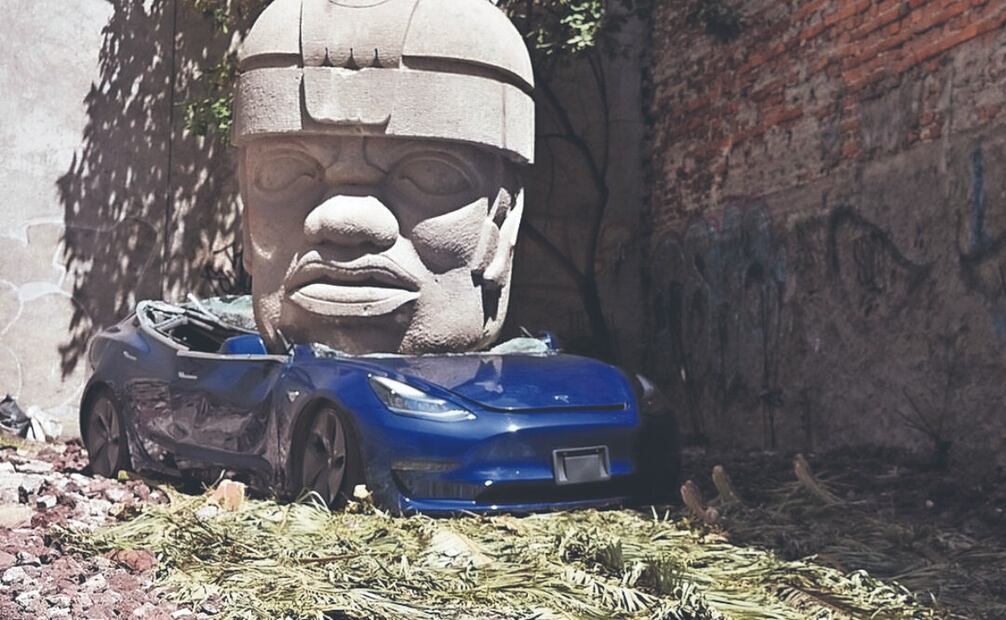 La instalación del artista Chavis Marmol, donde una cabeza olmeca aplasta un auto Tesla.
Foto: Especial 
