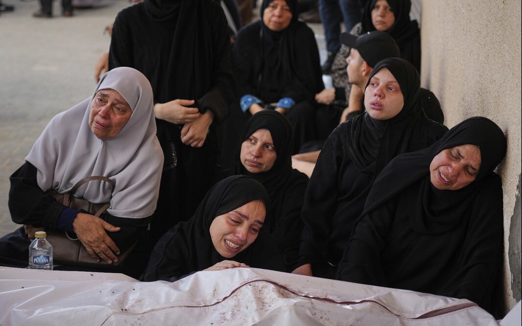 Varias mujeres se lamentan frente a los cuerpos de familiares muertos durante un bombardeo israelí, en Deir al-Balah, Franja de Gaza, el sábado 12 de julio de 2025. Foto: AP