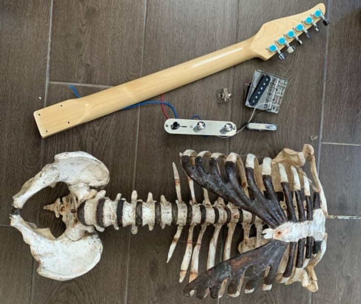 Músico presume guitarra eléctrica construida con el esqueleto de su tío