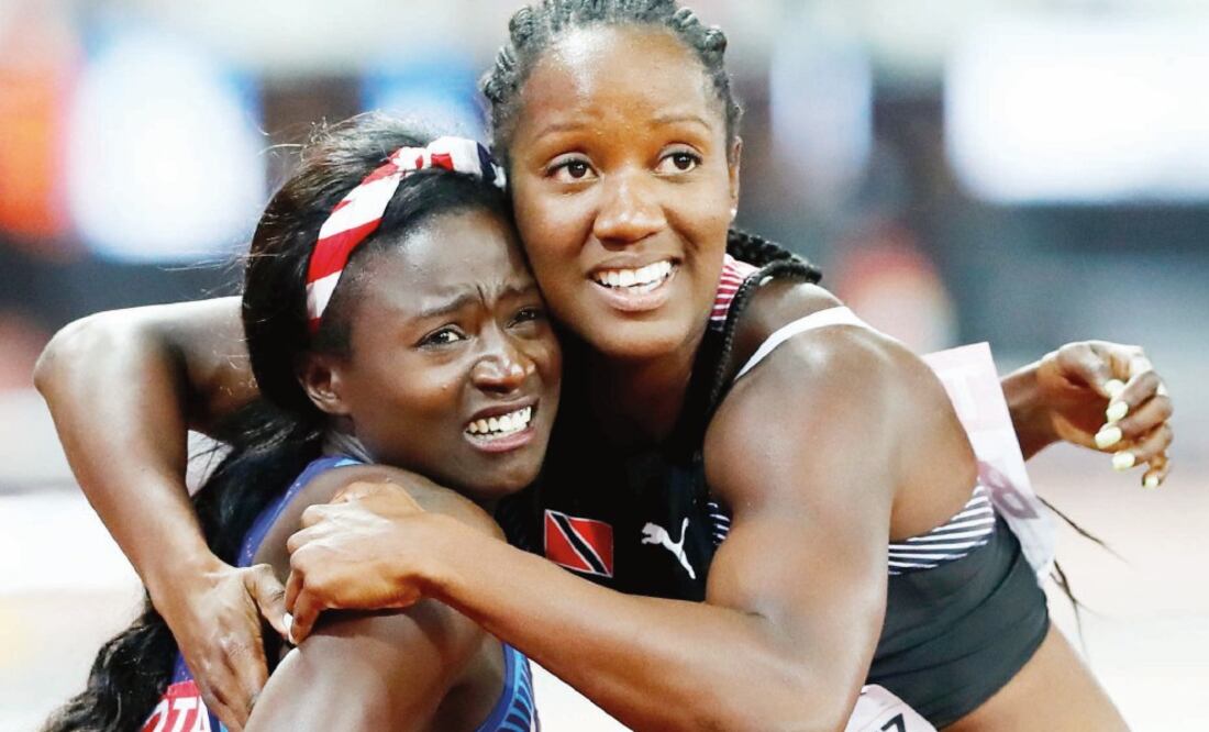 Tori Bowie, de EU y Kelly-Ann Baptiste, de TyT se abrazan al ver el resultado. (LUCY NICHOLSON. REUTERS)