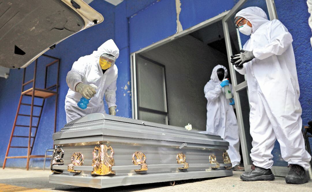 Workers wearing protective gear spray disinfectant on the coffin of a person who died from suspected COVID-19, as the body arrives at the crematorium at Xilotepec Cemetery in Xochimilco, Mexico City, Monday, July 27, 2020 - Photo: Rebecca Blackwell/AP