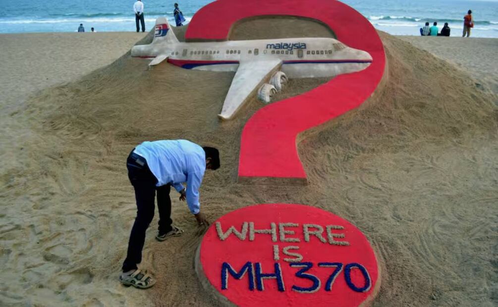 El artista indio Sudarsan Pattnaik crea una escultura de arena del vuelo desaparecido MH370 de Malaysia Airlines en la playa de Puri, en el estado oriental de Odisha, el 7 de marzo de 2015. Foto: 
J .K. JAGDEV - AFP