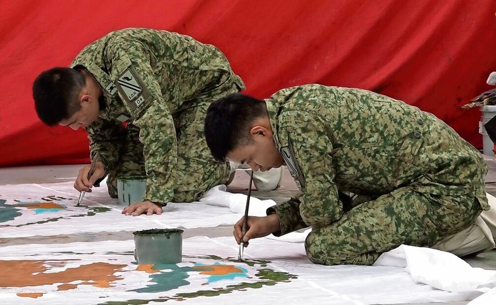 Elementos del Ejército pintan a pulso el Escudo Nacional de la Bandera.  Foto: Alberto González / EL UNIVERSAL