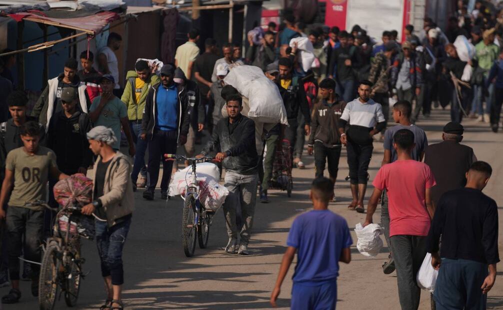 Palestinos cargan bolsas con comida y ayuda humanitaria entregada por la Fundación Humanitaria de Gaza, una organización con apoyo estadounidense y autorizada por Israel, el domingo 1 de junio de 2025, en Jan Yunis, en la Franja de Gaza. Foto: AP
