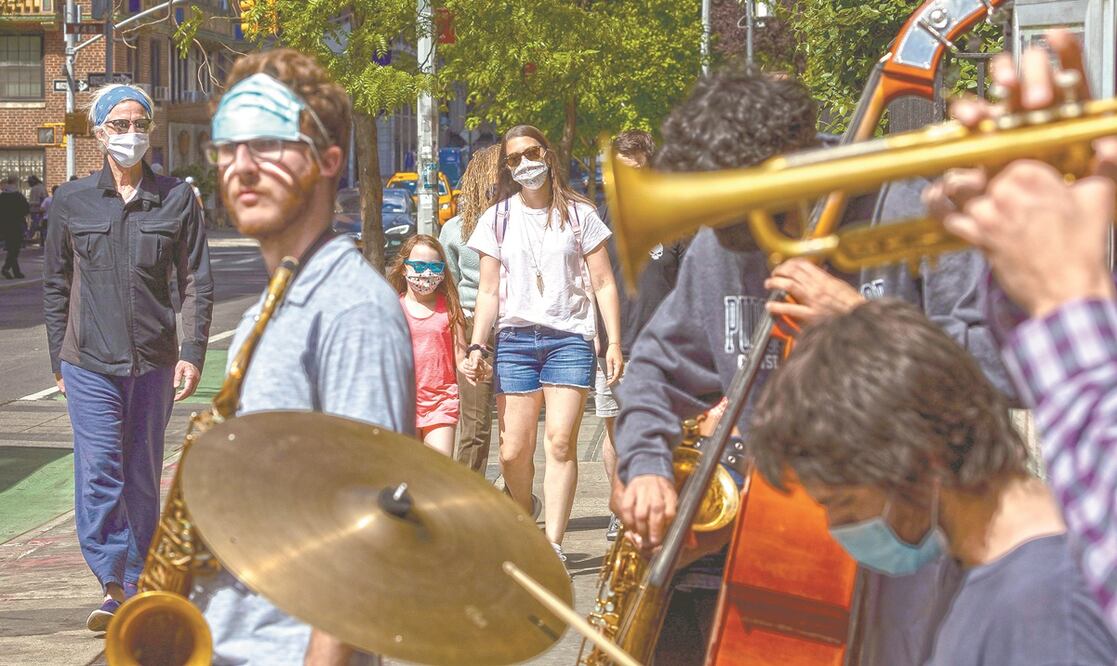 Jóvenes músicos en la esquina de una calle en Nueva York. Se sigue recomendando llevar mascarilla en medios de transporte. Foto: JUSTIN LANE. EFE