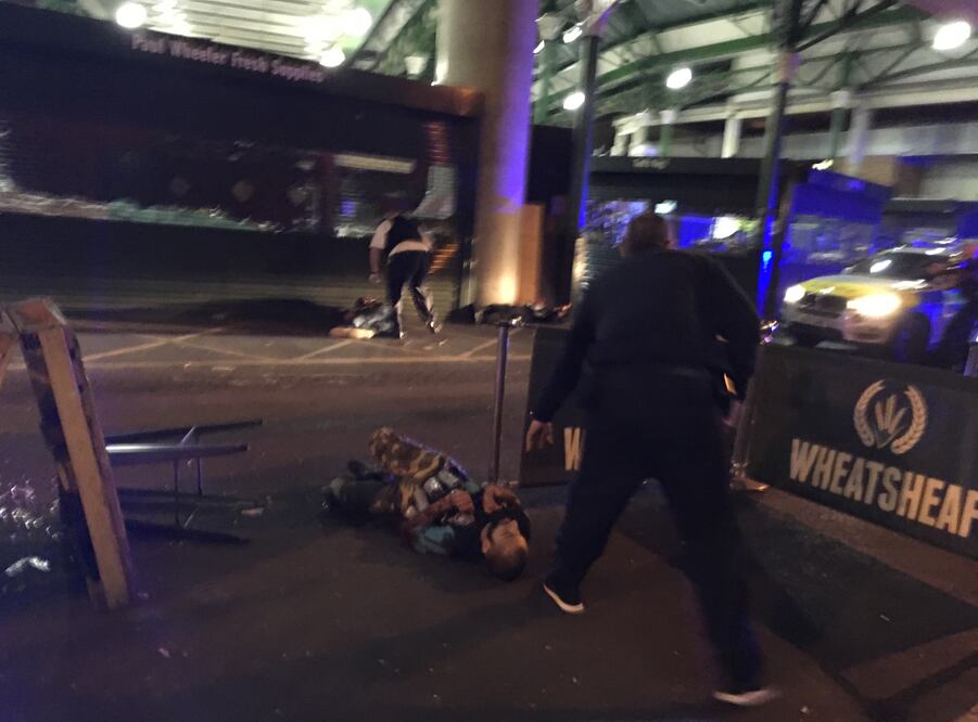 Un sospechoso, en el suelo, que parece llevar lo que parecen botes en el chaleco, tras ser baleado por la policía ante el Borough Market en Londres. (AP)