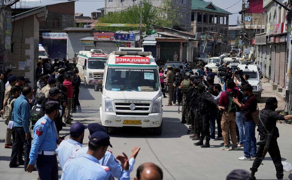 La policía hace guardia mientras ambulancias trasladan los cuerpos de turistas en Srinagar, en la Cachemira controlada por India. Foto: AP