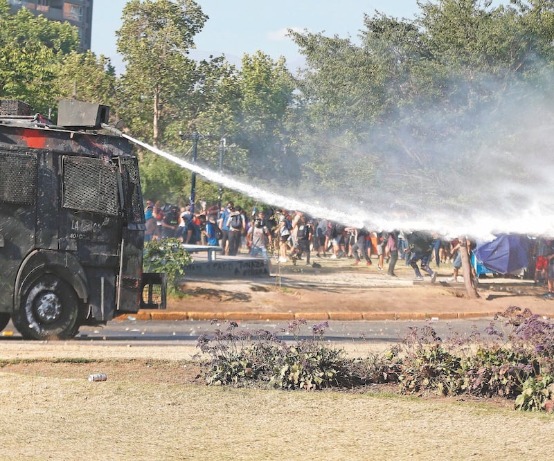En una nueva jornada de protestas, las Fuerzas Especiales de Carabineros y manifestantes se enfrentaron en la Plaza de la Dignidad, en Santiago. ALBERTO VALDÉS. EFE