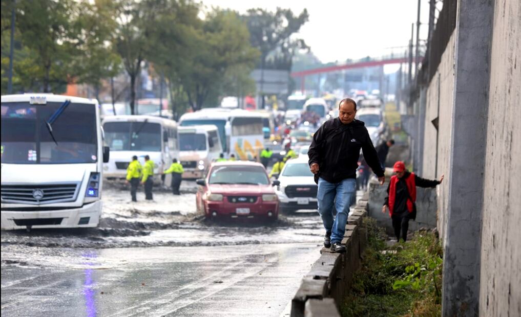 La gente trata de llegar a su destino caminando, sobre dovelas, en la plataforma de un camión de carga y hasta en la nariz de un camión de trasporte público concesionado, después de que la calzada Ignacio Zaragoza se encuentra inundada. Foto: Francisco Rodríguez/EL UNIVERSAL