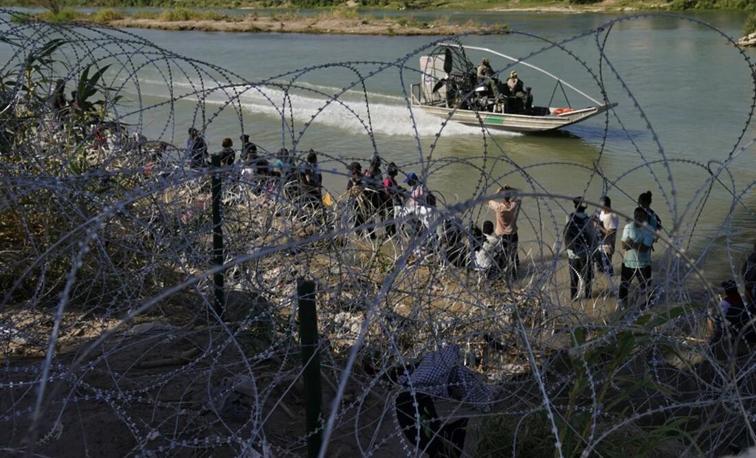 Migrantes que cruzaron a Estados Unidos desde México se encuentran con alambre de púas en la orilla del río Grande, en Eagle Pass, Texas. Foto: AP