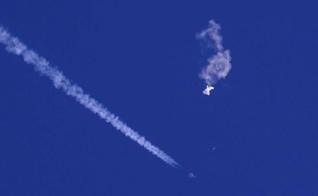 Restos del globo chino derribado sobre el océano Atlántico en la costa de Carolina del Sur con un avión de combate y su estela debajo. Foto: AP