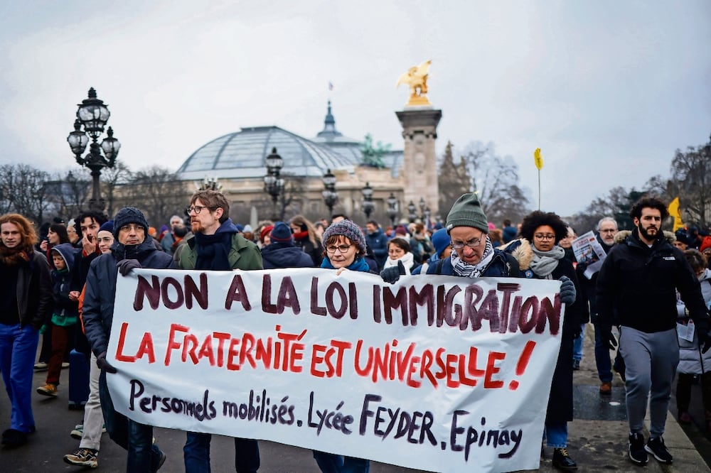 Manifestantes con una pancarta contra la ley de migración, en la protesta organizada por inmigrantes, sindicatos y partidos de izquierda en París. Foto: EFE