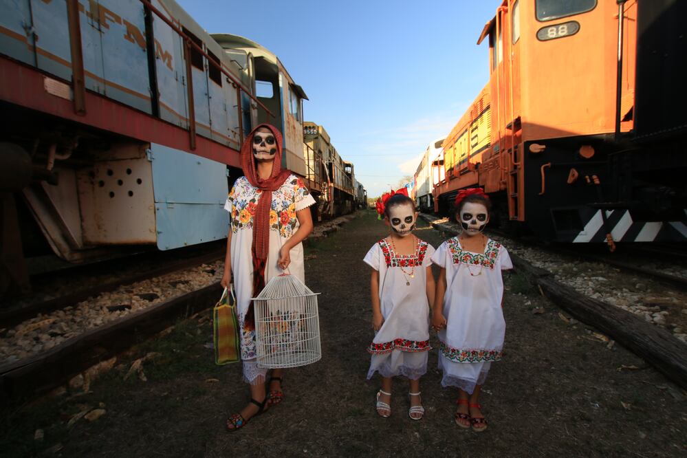 Con las caras pintadas de calavera y ataviados con el traje típico yucateco, hombres, mujeres y niños emprenden esta procesión