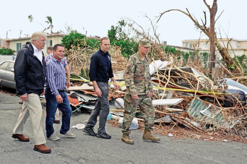 El presidente Donald Trump (izq.), con miembros de la agencia de emergencias (FEMA), al recorrer ayer Guaynabo, en Puerto Rico (EVAN VUCCI. AP)