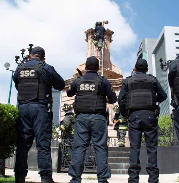 Artista hace performance en el pedestal del Monumento a Colón en Reforma como protesta