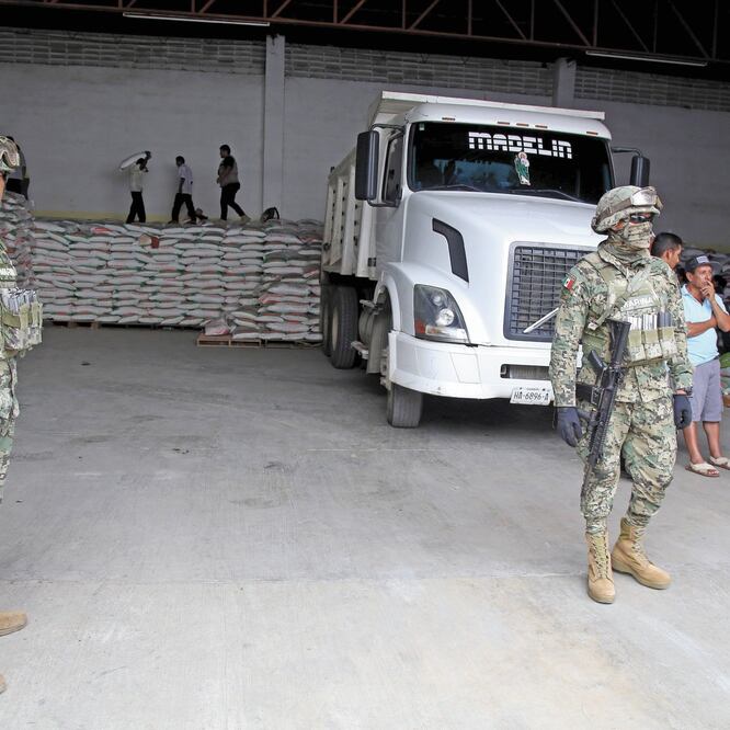 Elementos de la Marina vigilaron ayer la entrega a campesinos de costales de fertilizante en una bodega de la colonia Moctezuma, en la zona rural de Acapulco. CARLOS CARBAJAL. EL UNIVERSAL
