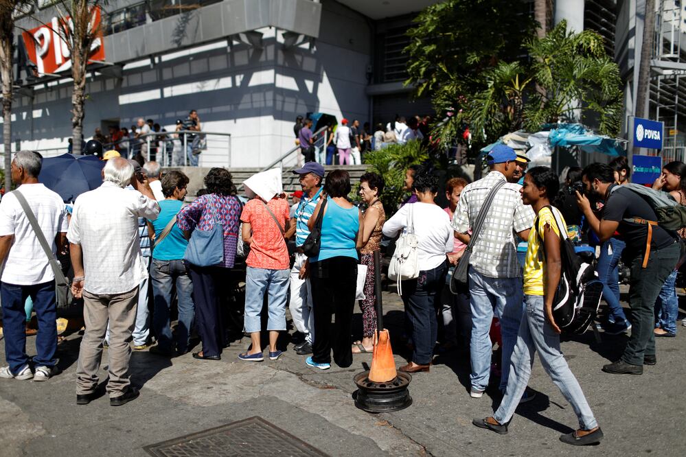 Personas esperando afuera de un supermercado en Caracas. (FOTO: REUTERS/Marco Bello)