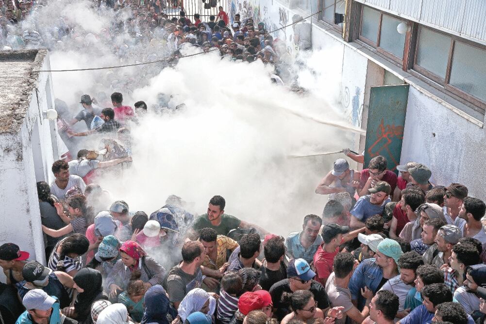 Policías intentan dispersar a cientos de migrantes que reclamaban mayor celeridad en sus procesos de registro, en la isla griega de Kos. Cientos de personas están llegando a esta zona cada día (YORGOS KARAHALIS. AP)